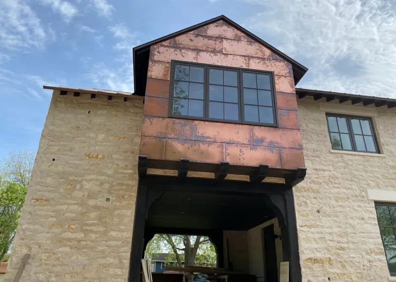 Copper metal panel facade on a stone building for Skylight Installation in Homer